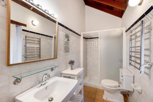 a white bathroom with a sink and a toilet at Casa Rural La Era in Valverde