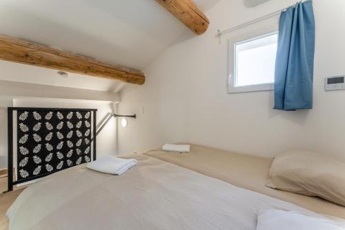 a bedroom with a large bed with a window at Canto Cigalo Duplex 12 in Robion en Luberon