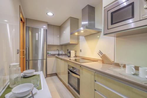 a kitchen with a stainless steel refrigerator and cabinets at Duplex Islantilla Golf in Huelva