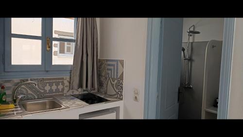 a small kitchen with a sink and a window at Pico Bello Patmos 26 in Patmos