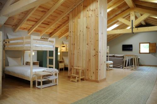 a bedroom with a bunk bed and a living room at El Albergue Rural in Mombeltrán