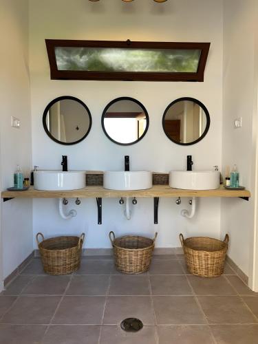 a bathroom with two sinks and two mirrors at El Albergue Rural in Mombeltrán