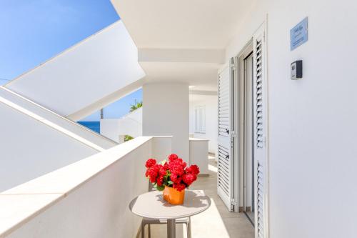 a vase of red flowers sitting on a table in a hallway at Residence Fronte Mare in Ugento