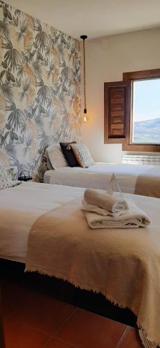 a hotel room with two beds and a window at La Casa 1950 in Montefrío