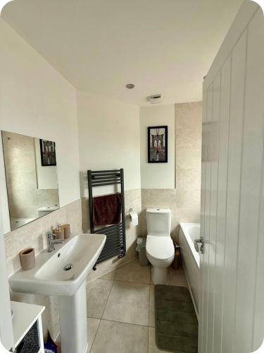 a bathroom with a sink and a toilet and a tub at Single room in Tamworth in Wigginton