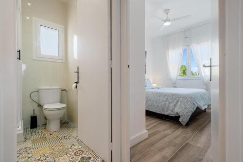 a bathroom with a bed and a toilet in a room at The Sunset Calafell in Calafell