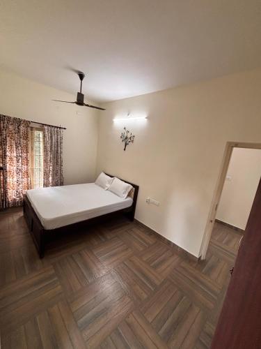 a bedroom with a bed and a wooden floor at Silver Breeze in Yercaud