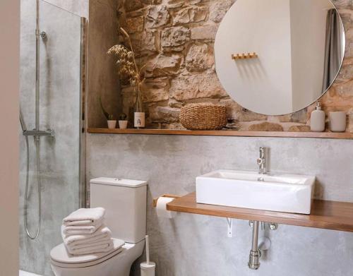 a bathroom with a sink and a toilet and a mirror at Casa Comalats in Montoliu de Segarra