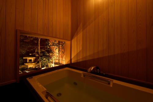 a bath tub in a room with a window at Kuraya Kamigojocho in Kyoto