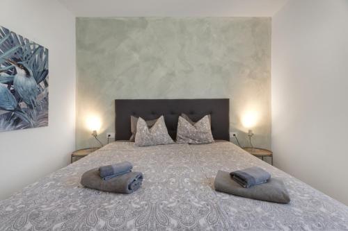 a bedroom with a large bed with two pillows on it at Casa Agua Y Sol I in Poris de Abona
