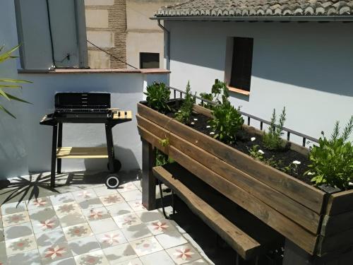 a patio with a piano and a bench with plants at Casa con terraza centro Granada y vistas Alhambra in Granada
