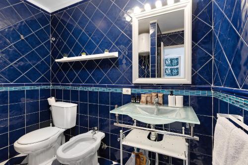 a blue tiled bathroom with a toilet and a sink at Holiday Valley Blue Ocean B2 in Adeje