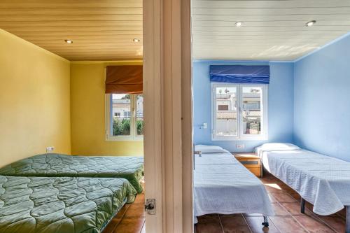 a room with two beds and two windows at Mimosa in L'Escala