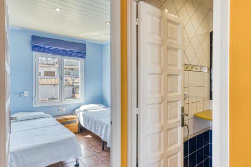 a small room with two beds and a door at Mimosa in L'Escala