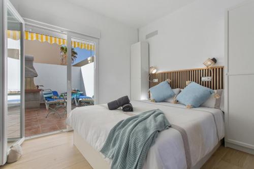 a bedroom with a large white bed with blue pillows at Neral relax in Las Playitas