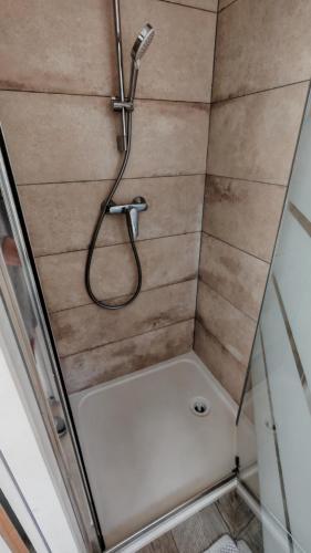 a shower with a hose in a bathroom at Casa Neptune in Sausset-les-Pins