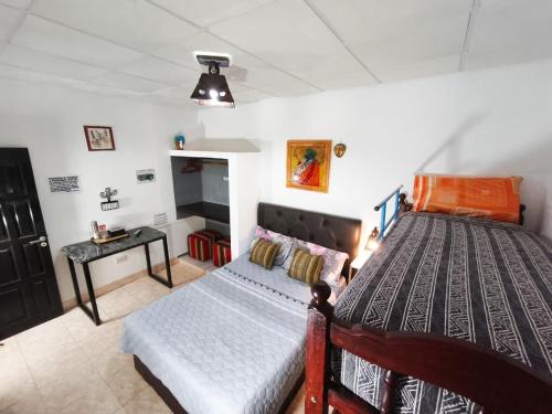 a bedroom with a large bed and a small table at Tilcara Hostal Niña Coya in Tilcara