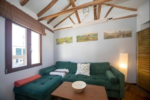 a living room with a green couch and a table at Casa con terraza centro Granada y vistas Alhambra in Granada