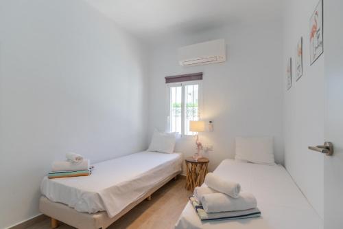 two beds in a room with white walls and a window at Villa Carolima - Heated Pool in Benissa