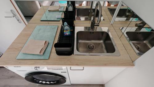 a kitchen counter with a sink and a washing machine at Casa Neptune in Sausset-les-Pins
