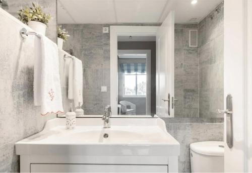 a white bathroom with a sink and a toilet at Denia Living in Denia