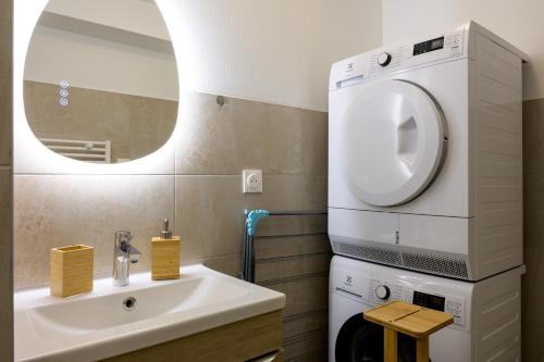 a bathroom with a sink and a washing machine at Au Bretzel in Ostheim