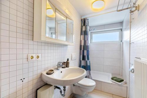 a white bathroom with a sink and a toilet at Ferienwohnung Seestern in Wester-Ohrstedt