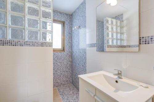 a white bathroom with a sink and a shower at Apartamento La Cabanya 2d in Canyamel