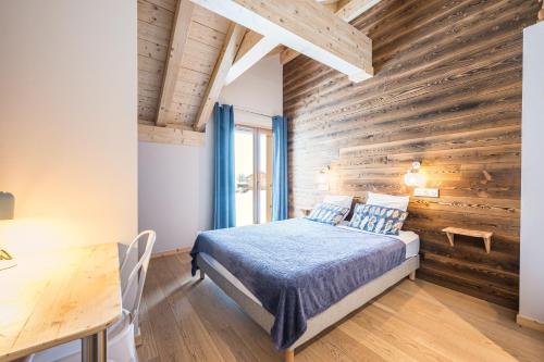 a bedroom with a bed and a wooden wall at Alphonsine Ski Lodge in La Toussuire