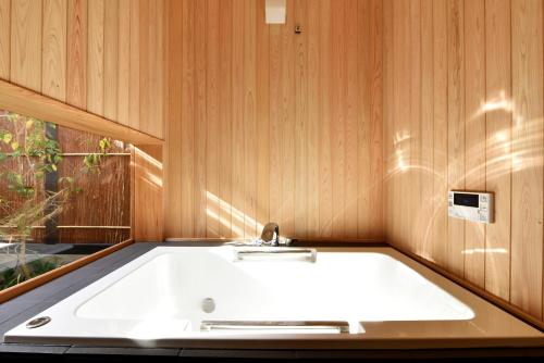 a white bath tub in a room with a window at Kuraya Kamigojocho in Kyoto