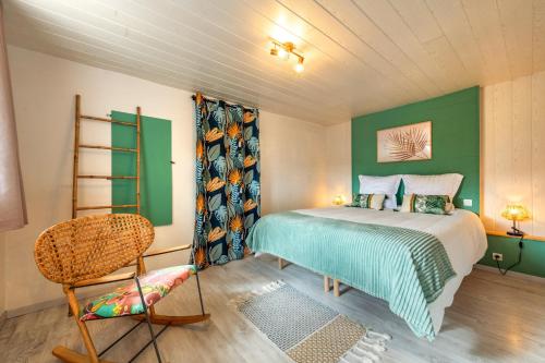 a bedroom with a bed and a chair at Ty Reuniou - La Grange in Cléder