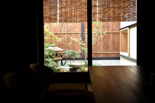 a view of a garden through a window at Kuraya Kamigojocho in Kyoto