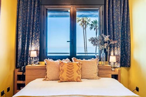 a bedroom with a bed and a window with the ocean at Cambrils seaside luxury solarium in Montroig