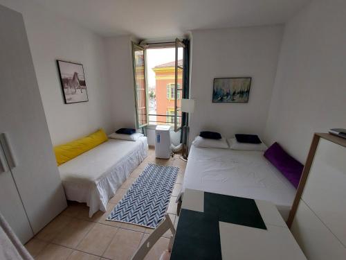a small room with two beds and a window at Lovely view in Nice