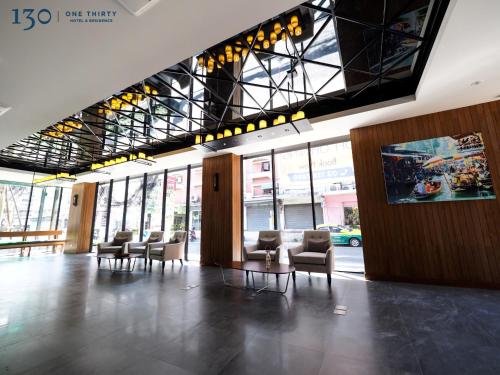 a lobby with a row of chairs in a building at 130 Hotel & Residence Bangkok in Bangkok