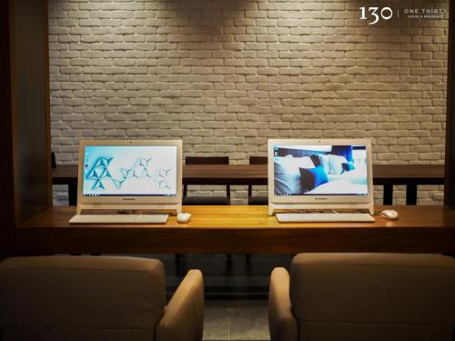 two laptop computers sitting on a wooden table at 130 Hotel & Residence Bangkok in Bangkok