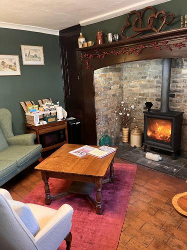 a living room with a table and a fireplace at The Globe House in Broseley