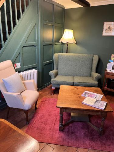 a living room with two chairs and a coffee table at The Globe House in Broseley
