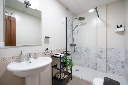 a bathroom with a sink and a shower at Piso arquillo del reloj in Chiclana de la Frontera