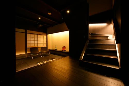 a room with a staircase and a chair and a window at Kuraya Kamigojocho in Kyoto