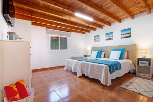 a bedroom with a large bed with blue pillows at Casa Valentina in Tuineje
