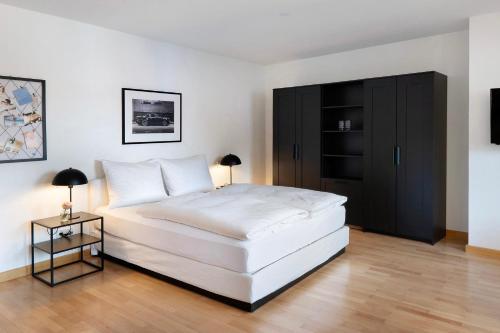 a bedroom with a white bed and a black cabinet at 1 Zimmer-appartment Nr 21 in Wangen im Allgäu