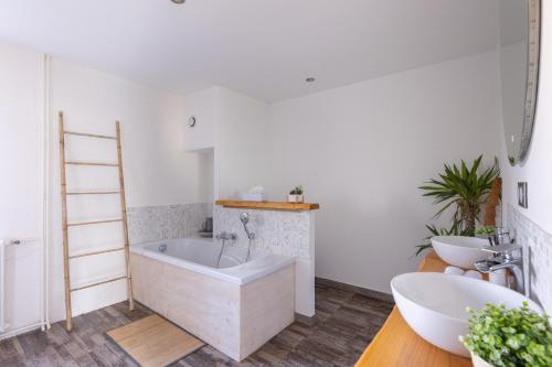 a bathroom with a tub and two sinks and a ladder at Les petits logis de l'Écluse in Noyers-sur-Cher