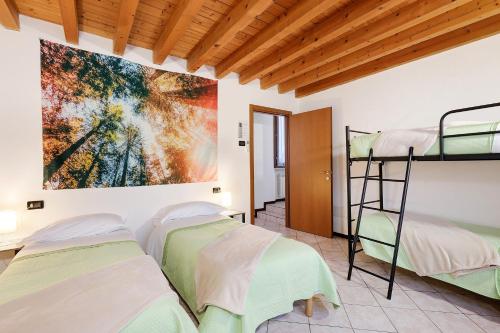 a room with four bunk beds and a painting on the wall at Il Vagabondo in Volta Mantovana