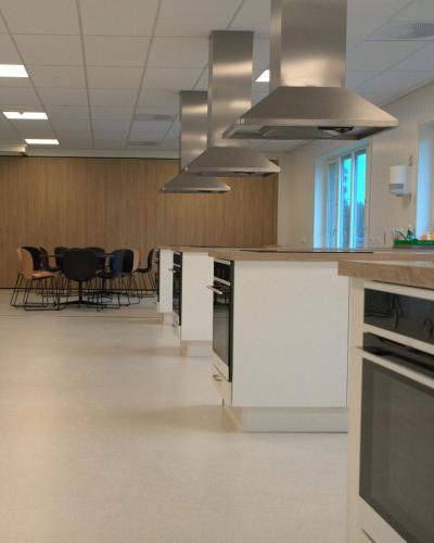 an empty room with a kitchen and a table at Evje Folkehøgskole in Evjemoen