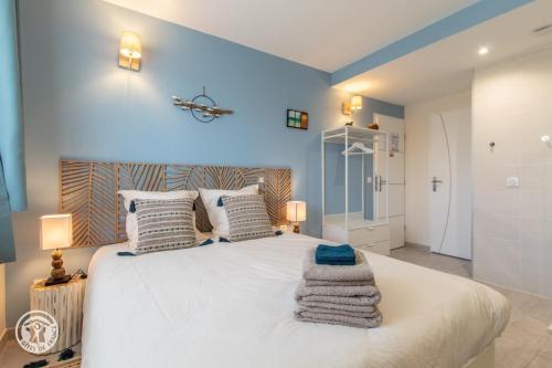 a bedroom with a large white bed with towels on it at Notre Petit Paradis in Annecy