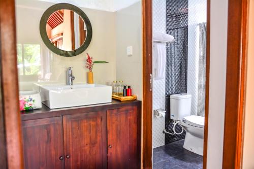 a bathroom with a sink and a mirror at Griya Sriwedari in Ubud
