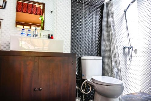 a bathroom with a toilet and a sink and a shower at Griya Sriwedari in Ubud