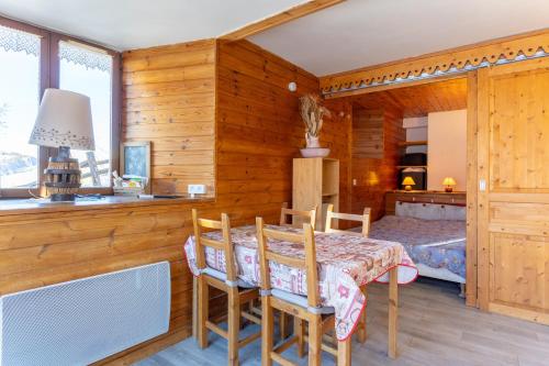 a dining room with a table and chairs and a bedroom at L'Alpazen Jouve Studio Terrasse in Saint-Véran