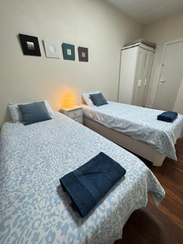 a bedroom with two beds with blue towels on them at Apartamento Villarias in Bilbao